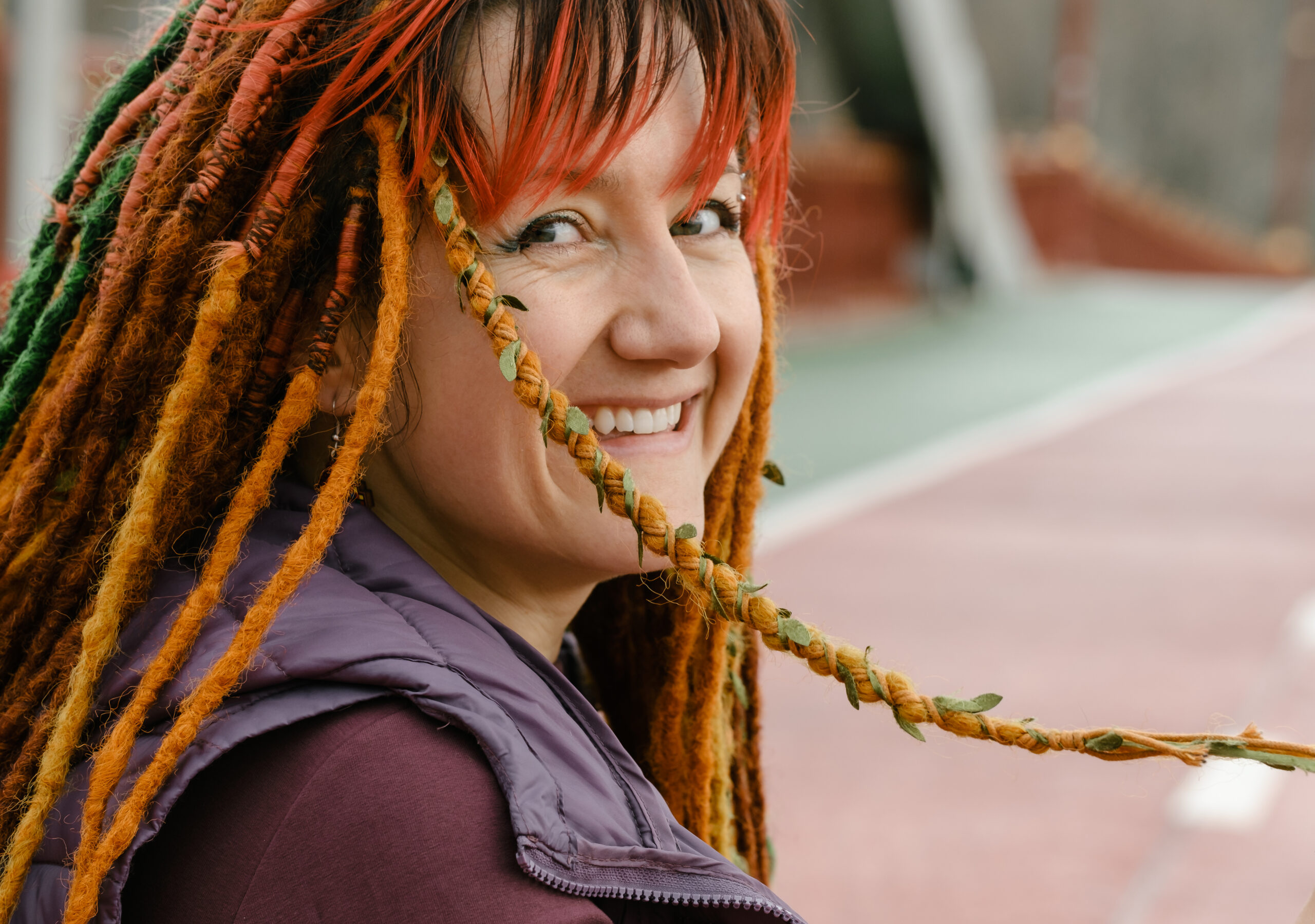Bright woman with colorful braids on the road